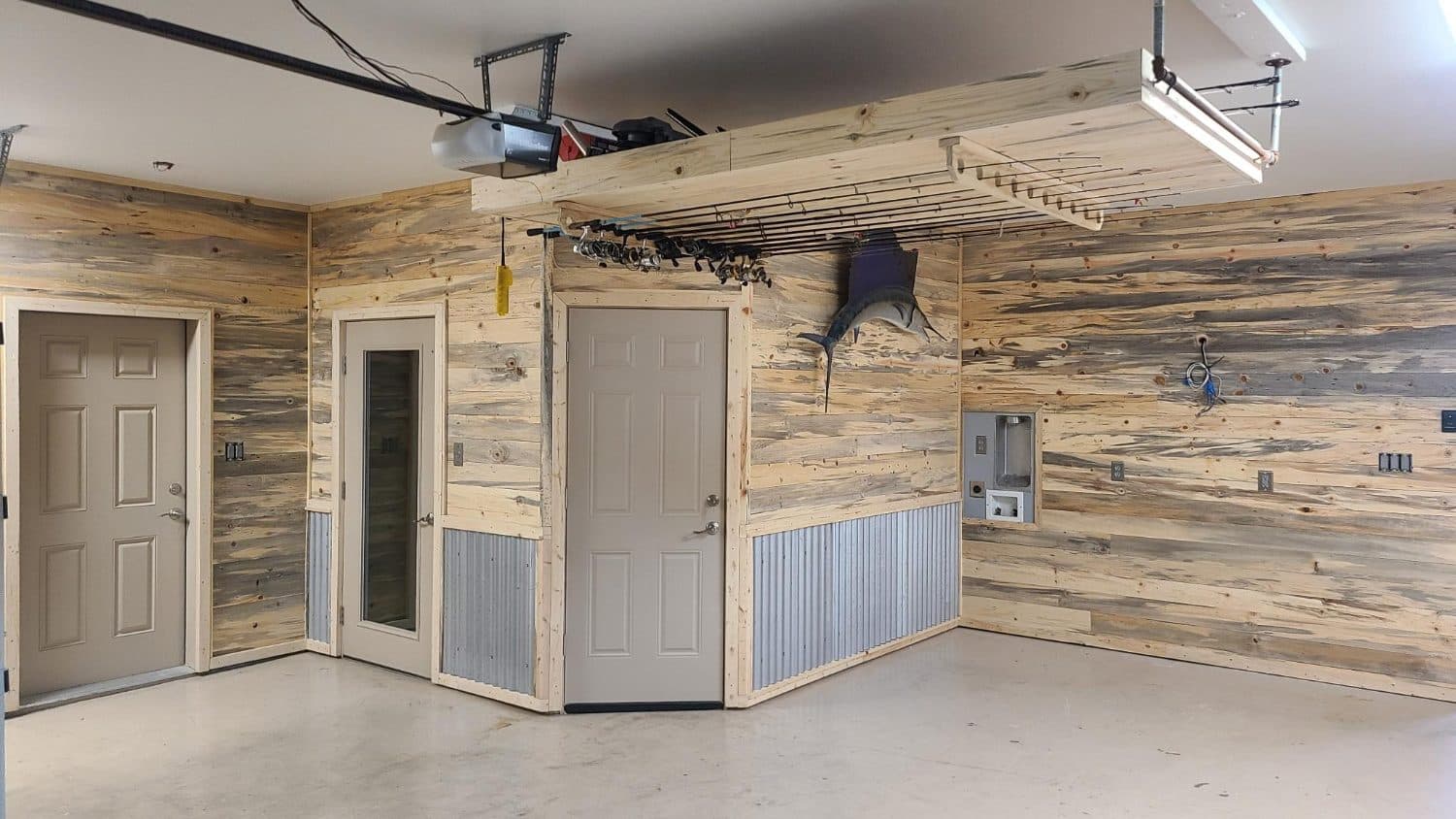 Garage after: beetle-kill pine walls with corrugated metal wainscot and an overhead rod rack